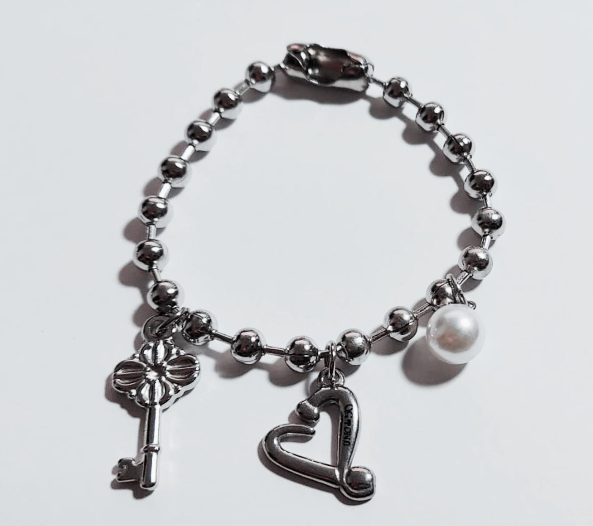 PULSERA EN STAINLESS STEEL CON COLGANTE DE CORAZON, LLAVE Y PERLA